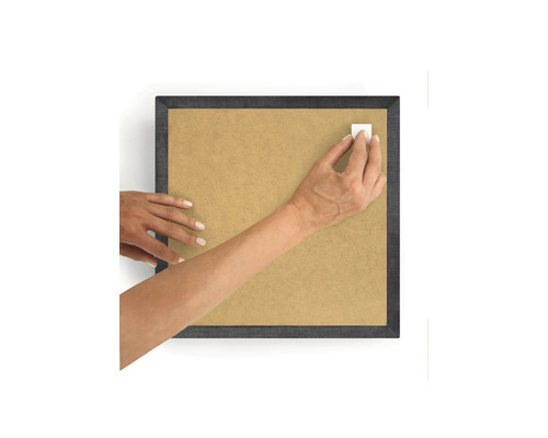 O persoană fixează o bandă adezivă pe o ramă foto.