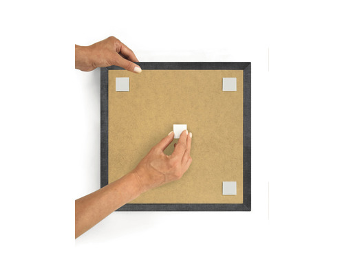 Persoană care atașează plăcuțe adezive pe o ramă foto