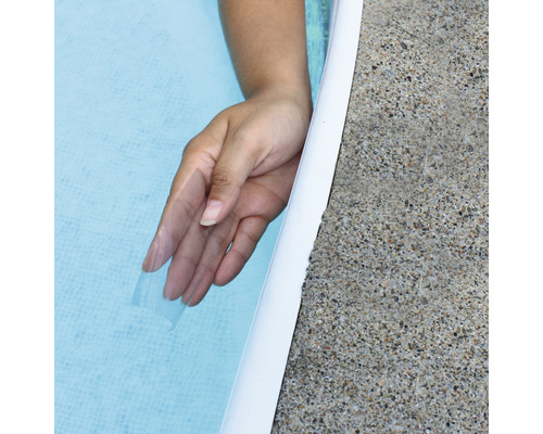 Mână în apa piscinei lângă marginea piscinei