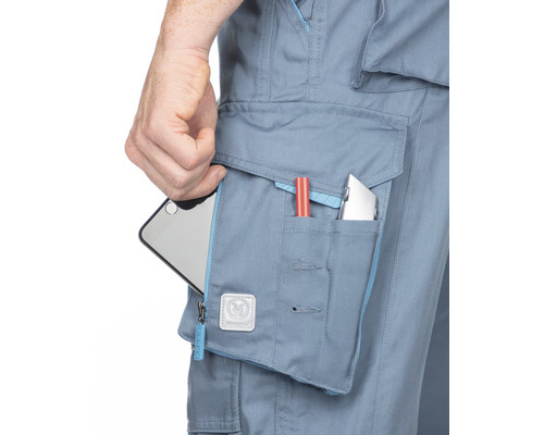 Prim-plan cu pantaloni de lucru cu mai multe buzunare care conțin un smartphone, un stilou și un cuțit