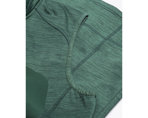 Prim-plan cu un top sport verde cu cusături și inscripție de marcă