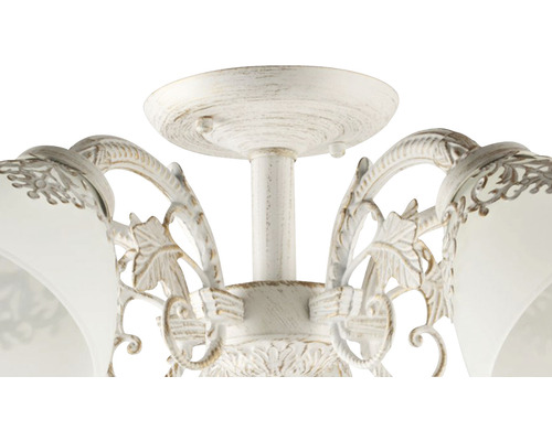 Prim-plan al unei lămpi de tavan cu decorațiuni florale.