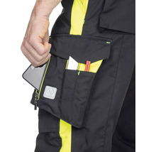 Prim-plan cu pantaloni de lucru cu buzunare care conțin un smartphone, un stilou și un cuțit