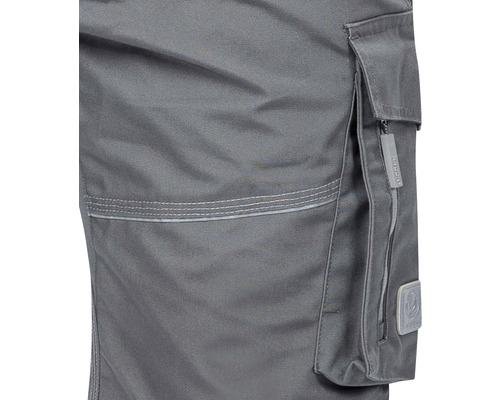 Detaliu al unor pantaloni de lucru gri cu buzunar lateral și fermoar