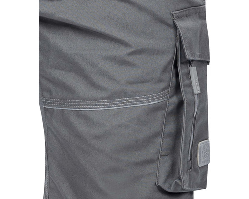 Detaliu al unui pantalon de lucru cu buzunar lateral și fermoar