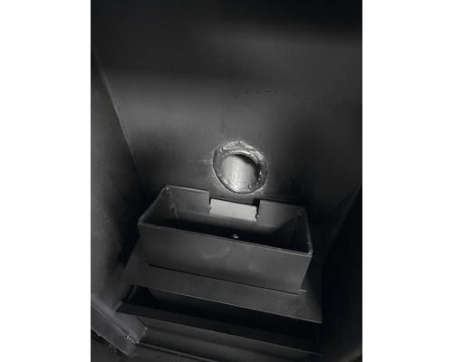 Vedere interioară a unui șemineu pe lemne cu racord pentru coșul de fum și cenușar