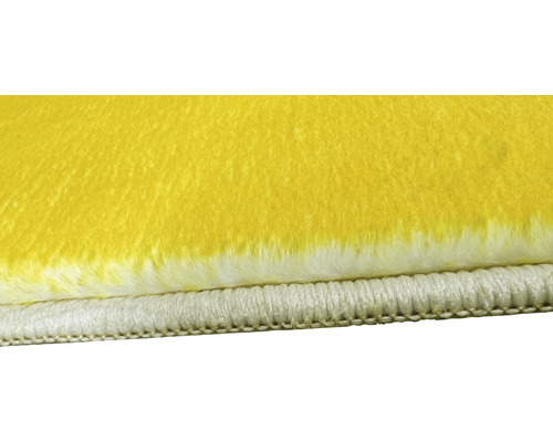 Detaliu al unui covor galben cu partea inferioară albă