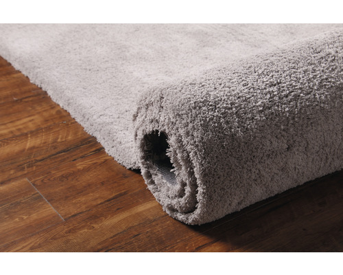 Covor gri rulat pe podea de lemn