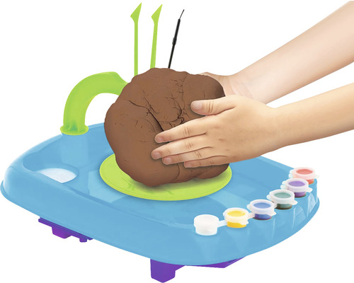 Roată de olar cu argilă, culori și mâinile unui copil