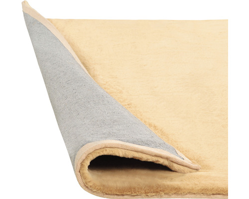 Covor bej cu marginea îndoită care arată partea de jos