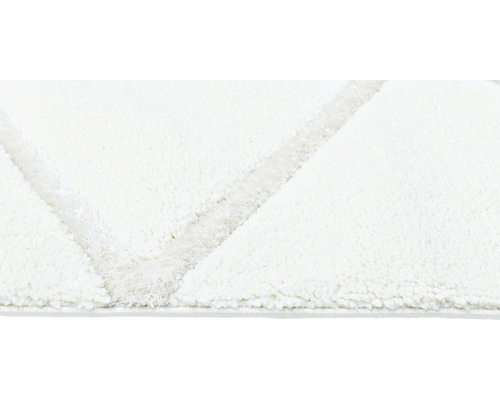 Imagine detaliată a unui covor alb cu model geometric