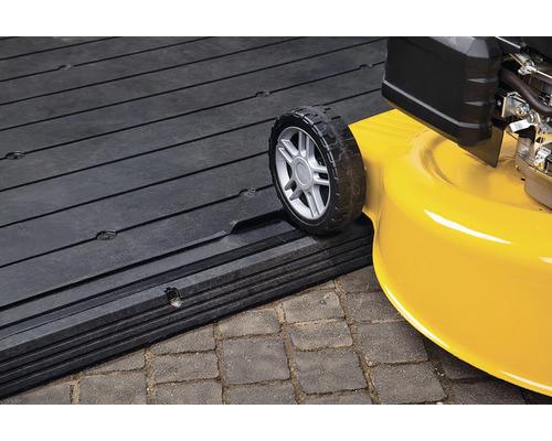 Tractor de gazon care urcă pe o rampă de încărcare