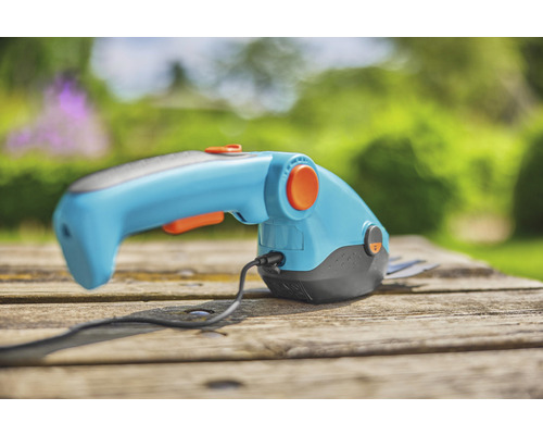 Foarfecă cu acumulator pentru lucrări de grădinărit pe o masă din lemn