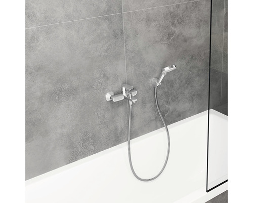 Fotografie cu un robinet de duș aparent cu duș de mână la o cadă