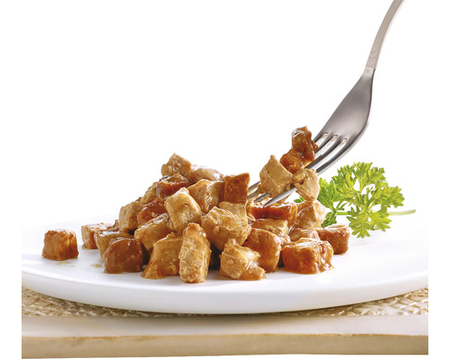 Gramadă de cuburi de carne pe o farfurie cu o furculiță și pătrunjel