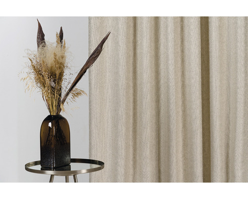 Flori uscate decorative în vază pe o masă mică în fața unei perdele