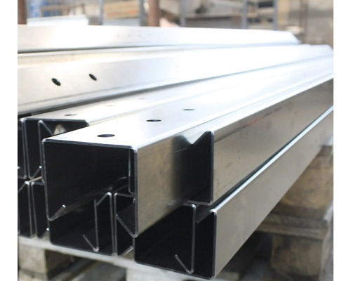 Profile de oțel cu găuri stivuite pe un palet.