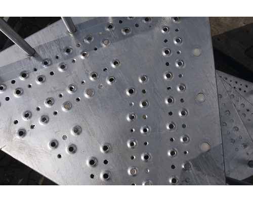 Prim-plan al unei trepte metalice cu găuri