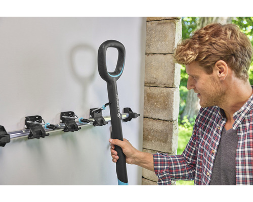 Suport pentru scule Gardena cu un bărbat care agață o lopată