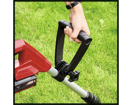 Prim-plan cu o persoană care ține mânerul unei mașini de tuns iarba.