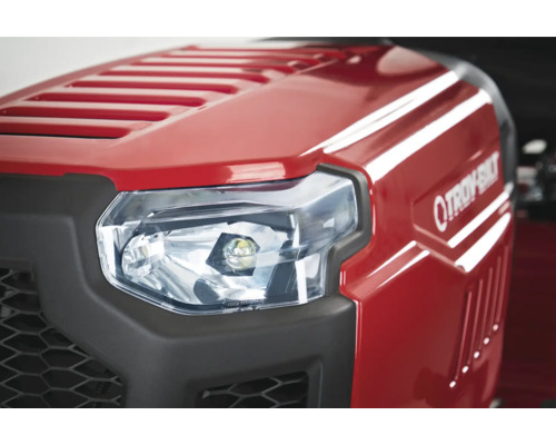 Prim-plan cu farul unui tractor de gazon roșu Troy-Bilt.