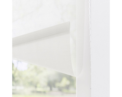 Prim-plan al unei rulouri albe în fața unei ferestre