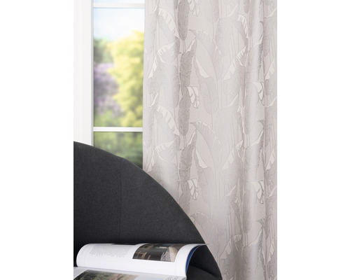 Cortină cu model de frunze în fața unei ferestre