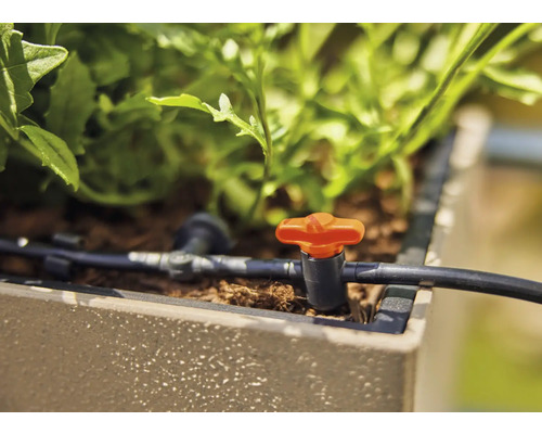 Sistem de irigare prin picurare cu supapă de reglare într-o jardinieră.