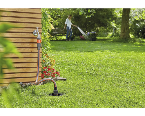 Scenă de grădină cu robinet de apă, furtun de grădină și aspersor pentru irigare