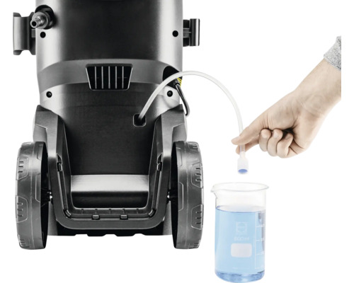 Aparat de curățat cu presiune înaltă cu furtun de aspirație scufundat într-un pahar Berzelius umplut cu detergent