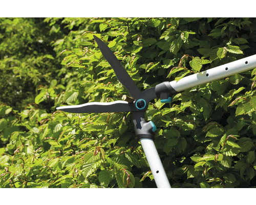 Foarfece de gard viu cu mâner telescopic care taie un gard viu