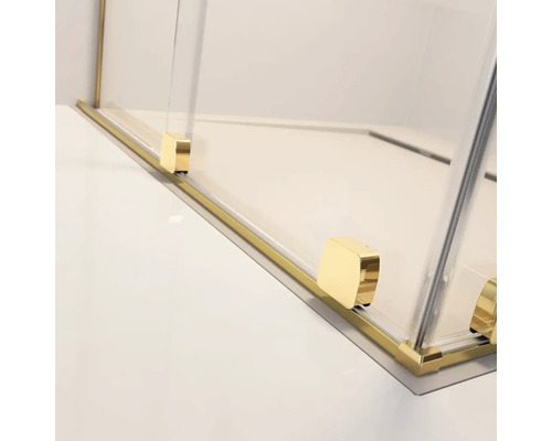 Detaliu al unei cabine de duș cu feronerie aurie și panouri de sticlă transparentă