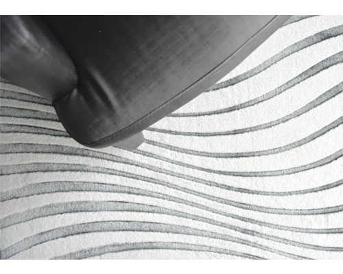 Detaliu covor cu model ondulat și fotoliu