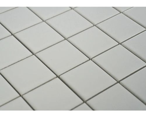 Prim-plan cu plăci pătrate aranjate în diagonală, formând un model repetitiv.