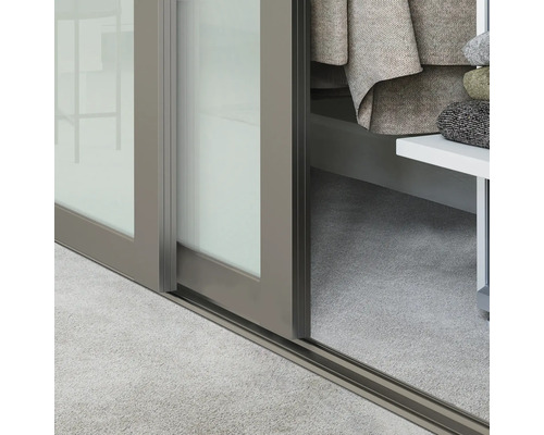 Prim-plan cu o ușă glisantă cu cadru metalic și șină de podea.