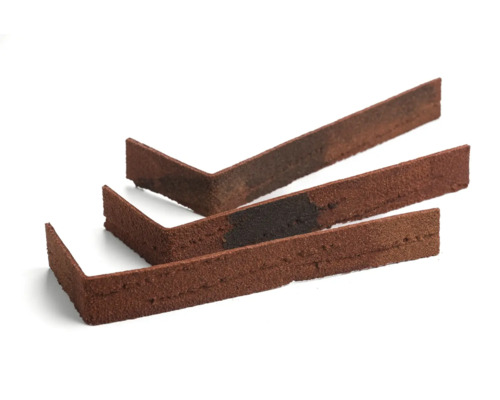 Trei piese de colț cărămizi decorative maro-roșcate pe un fundal alb