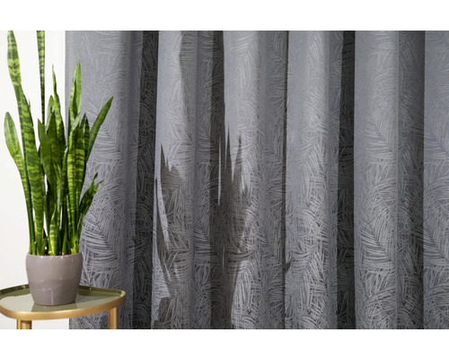 Șaluri decorative cu model de frunze lângă o plantă de interior pe o masă