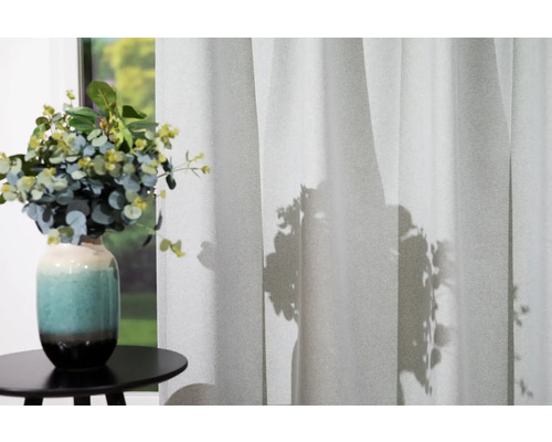 Șaluri decorative în fața ferestrei cu vază de flori pe masă