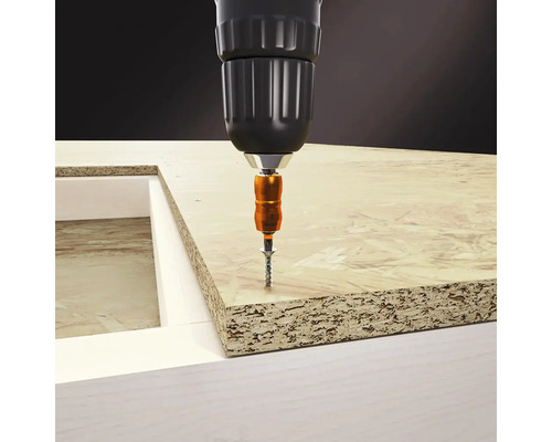 Șurub înșurubat într-o placă de lemn cu o șurubelniță fără fir.