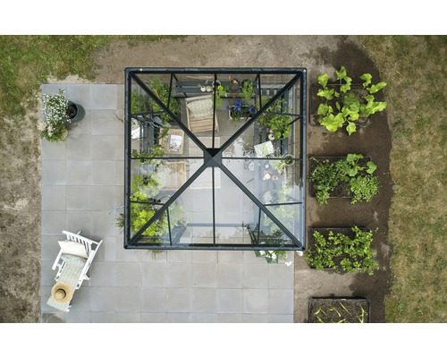 Vedere de sus a unei sere cu plante și mobilier de grădină pe o terasă.