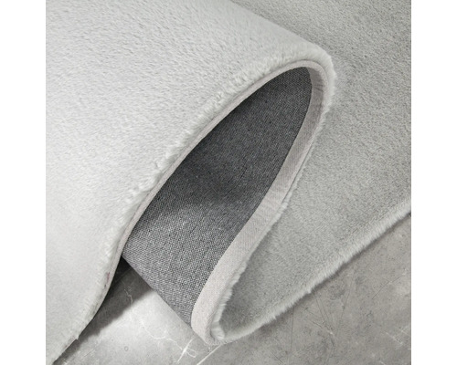 Vizualizare detaliată a unui covor de culoare deschisă cu fibre textile