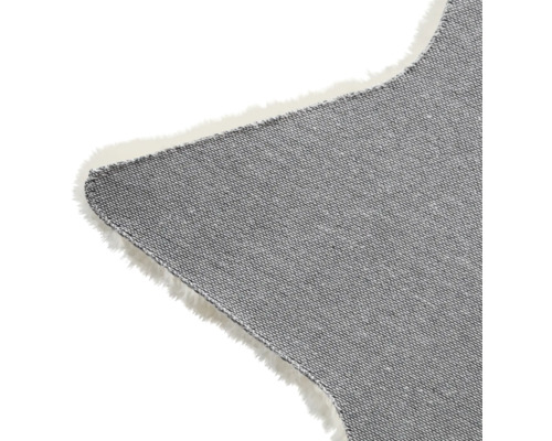 Detalii ale unui covor gri în formă de stea, cu franjuri