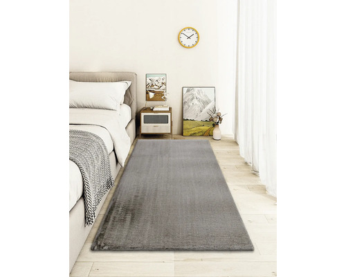 Covor gri într-un dormitor cu pat și noptieră