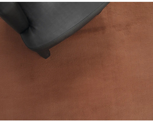 Prim-plan cu un fotoliu negru pe un covor.