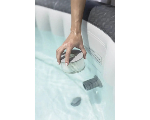 O mână ține un filtru într-o cadă cu hidromasaj.