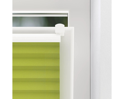 Prim-plan cu un jaluzea plisată verde la fereastră