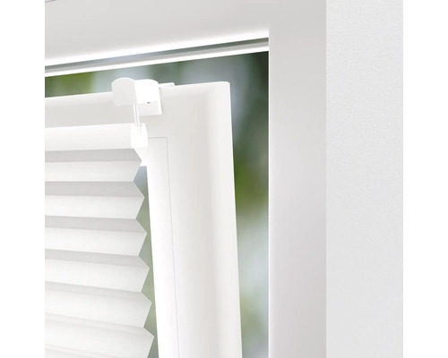 Prim-plan cu un jaluzele plisate albe pe fereastră