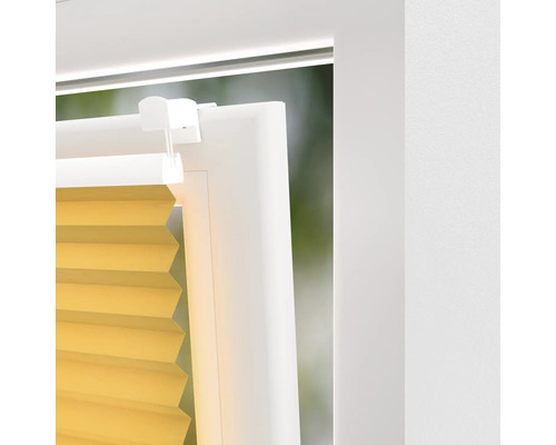 Imagine detaliată cu un jaluzea plisată galbenă la o fereastră