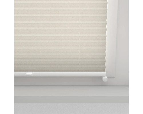 Jaluzea plisată bej pe o fereastră