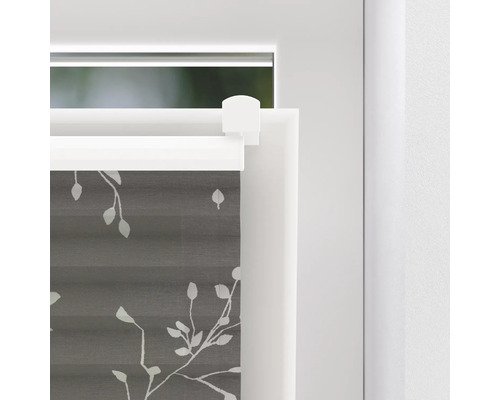 Prim-plan cu o draperie plisată gri cu model de frunze pe o fereastră